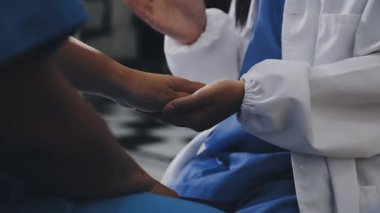 female doctor in medical uniform holding hand in hospital ward