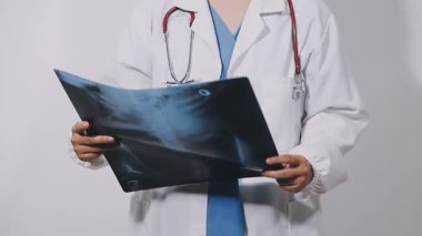 doctor shows the x - ray in the hands, isolated on gray background