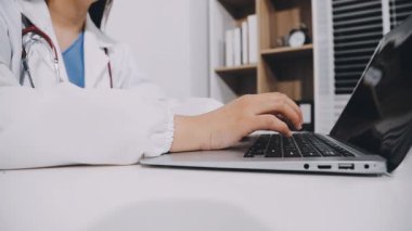 doctor working on laptop computer at office desk