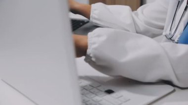 doctor working on laptop computer in hospital office, medical technology and medical healthcare concept.