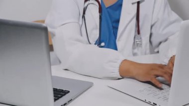 close - up of doctor 's hand typing on laptop computer at hospital