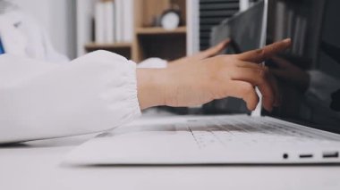 young woman doctor using laptop in hospital office. healthcare and medical concept.