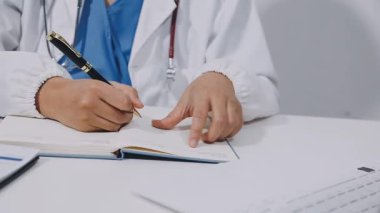 doctor writing on a clipboard in a hospital.