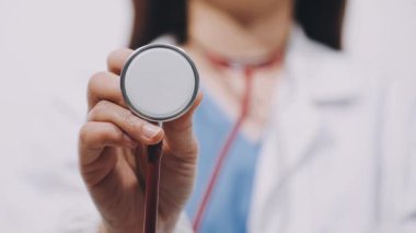 doctor in a white uniform holding a red heart in the hospital.