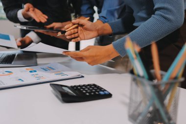 Muhasebe şirketi kazançlı nakit akışı için finansman ve vergilendirme planlaması, ofiste çalışan denetçi ve muhasebeci ekibi, mali verileri ve muhasebe kayıtlarını hesap makinesiyle analiz eder.