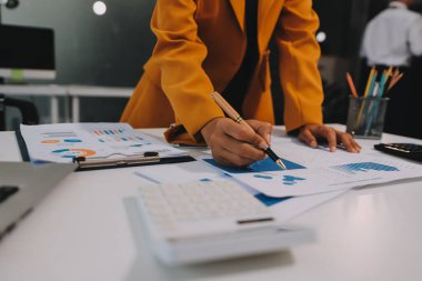 Muhasebe şirketi kazançlı nakit akışı için finansman ve vergilendirme planlaması, ofiste çalışan denetçi ve muhasebeci ekibi, mali verileri ve muhasebe kayıtlarını hesap makinesiyle analiz eder.