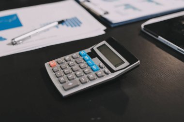 Muhasebe şirketi kazançlı nakit akışı için finansman ve vergilendirme planlaması, ofiste çalışan denetçi ve muhasebeci ekibi, mali verileri ve muhasebe kayıtlarını hesap makinesiyle analiz eder.