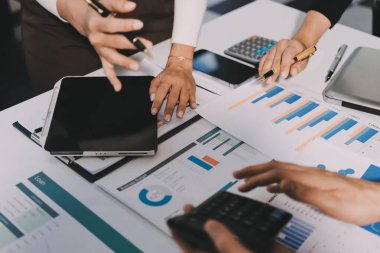 Muhasebe şirketi kazançlı nakit akışı için finansman ve vergilendirme planlaması, ofiste çalışan denetçi ve muhasebeci ekibi, mali verileri ve muhasebe kayıtlarını hesap makinesiyle analiz eder.