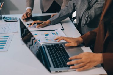 Muhasebe şirketi kazançlı nakit akışı için finansman ve vergilendirme planlaması, ofiste çalışan denetçi ve muhasebeci ekibi, mali verileri ve muhasebe kayıtlarını hesap makinesiyle analiz eder.