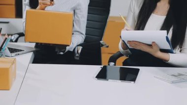 Genç Asyalı iş kadınları dijital tablet kullanıyor ve işe gülümsüyor.