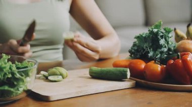 Genç bir kadın mutfakta yemek pişiriyor.