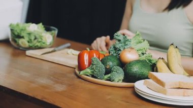 Kadın mutfakta yemek pişiriyor.