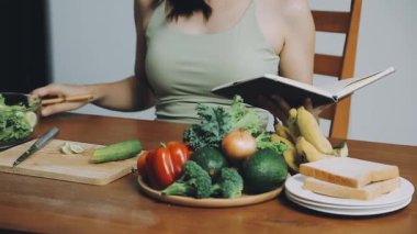 Masada salata yerken kitap okuyan kadın..