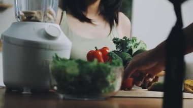 Genç bir kadın mutfakta yemek pişiriyor.