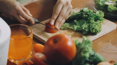 Kadın mutfak masasında taze sebze salatası pişiriyor.