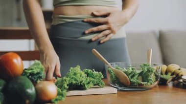 Genç bir kadın sağlıklı salataya hazırlanıyor. Kadın salata hazırlıyor.