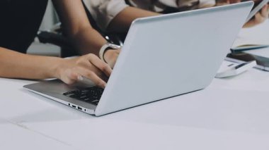 Genç iş kadını ofiste dizüstü bilgisayar kullanıyor..