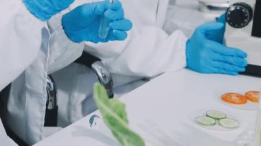 Laboratuvar asistanı kan dolu test tüpleri tutuyor..