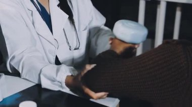 Kadın doktor hasta elini tutuyor.