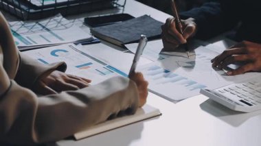 Modern ofiste evrak işleriyle uğraşırken gündelik kıyafetlerle gezen genç bir adam.