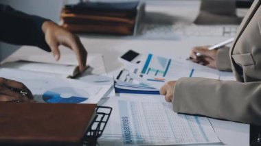 Modern ofiste masasında hesap makinesi tutan erkeklerin yakın plan fotoğrafları.