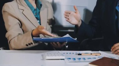 İşadamlarının elleri dizüstü bilgisayarlı ve belgeli bir ofiste yaptıkları toplantıda..