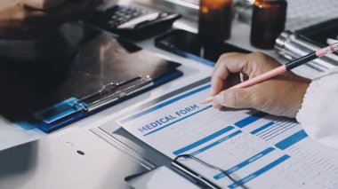 Üniformalı erkek doktor klinikte deftere yazıyor.