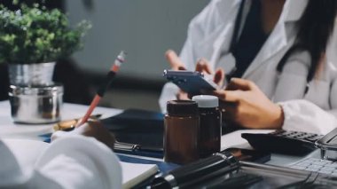 Doktor iş yerinde akıllı telefon kullanıyor. arka planda tableti olan doktor.