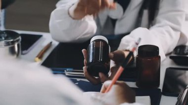 yakın plan - beyaz önlüklü genç bir adamın elleri beyaz arka plana oje sürüyor