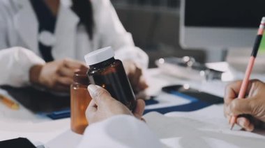 Tıp doktoru elinde bir şişe hap tutuyor.