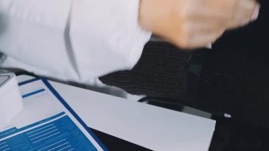 Masasında evrakları olan siyah ceketli bir kadın.