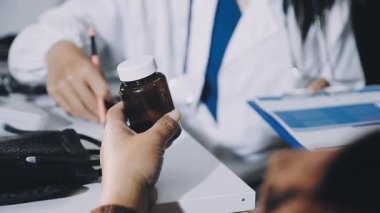 Yakın plan - elinde ilaç haplarıyla elinde şişe tutan kadın doktor..