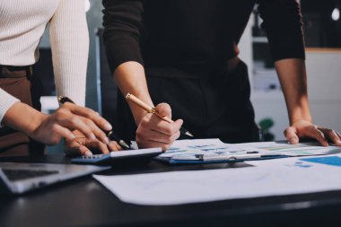 Muhasebe şirketi kazançlı nakit akışı için finansman ve vergilendirme planlaması, ofiste çalışan denetçi ve muhasebeci ekibi, mali verileri ve muhasebe kayıtlarını hesap makinesiyle analiz eder.