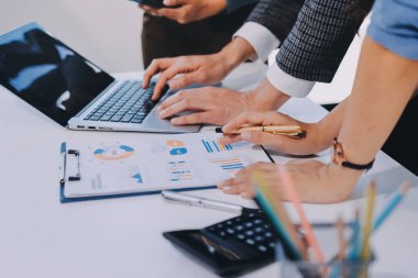 Muhasebe şirketi kazançlı nakit akışı için finansman ve vergilendirme planlaması, ofiste çalışan denetçi ve muhasebeci ekibi, mali verileri ve muhasebe kayıtlarını hesap makinesiyle analiz eder.