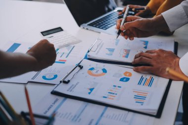 Muhasebe şirketi kazançlı nakit akışı için finansman ve vergilendirme planlaması, ofiste çalışan denetçi ve muhasebeci ekibi, mali verileri ve muhasebe kayıtlarını hesap makinesiyle analiz eder.