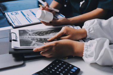 Hastane konferans salonunda kıdemli hekimin sunumu ve sağlık uygulamaları üzerine profesyonel eğitim oturumuna katılan bir grup doktor