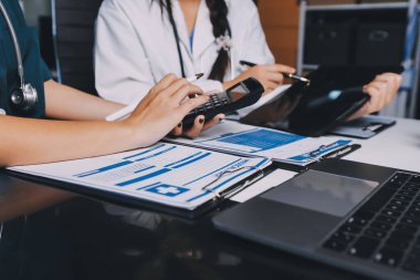 Hastane konferans salonunda kıdemli hekimin sunumu ve sağlık uygulamaları üzerine profesyonel eğitim oturumuna katılan bir grup doktor