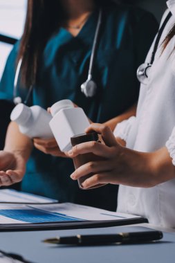 Hastane konferans salonunda kıdemli hekimin sunumu ve sağlık uygulamaları üzerine profesyonel eğitim oturumuna katılan bir grup doktor