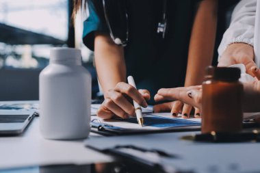 Hastane konferans salonunda kıdemli hekimin sunumu ve sağlık uygulamaları üzerine profesyonel eğitim oturumuna katılan bir grup doktor