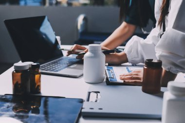 Hastane konferans salonunda kıdemli hekimin sunumu ve sağlık uygulamaları üzerine profesyonel eğitim oturumuna katılan bir grup doktor