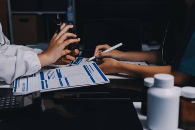 Hastane konferans salonunda kıdemli hekimin sunumu ve sağlık uygulamaları üzerine profesyonel eğitim oturumuna katılan bir grup doktor