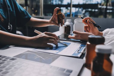 Hastane konferans salonunda kıdemli hekimin sunumu ve sağlık uygulamaları üzerine profesyonel eğitim oturumuna katılan bir grup doktor