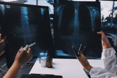 Hastane konferans salonunda kıdemli hekimin sunumu ve sağlık uygulamaları üzerine profesyonel eğitim oturumuna katılan bir grup doktor