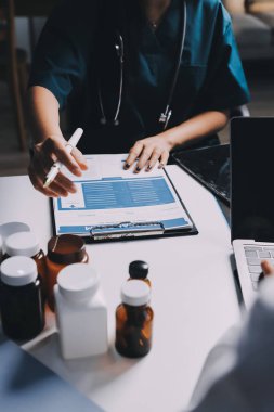 Hastane konferans salonunda kıdemli hekimin sunumu ve sağlık uygulamaları üzerine profesyonel eğitim oturumuna katılan bir grup doktor