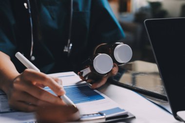 Hastane konferans salonunda kıdemli hekimin sunumu ve sağlık uygulamaları üzerine profesyonel eğitim oturumuna katılan bir grup doktor