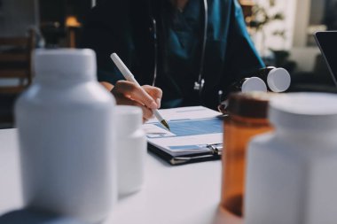 Hastane konferans salonunda kıdemli hekimin sunumu ve sağlık uygulamaları üzerine profesyonel eğitim oturumuna katılan bir grup doktor