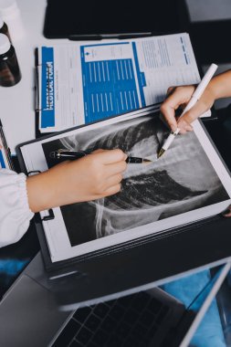 Hastane konferans salonunda kıdemli hekimin sunumu ve sağlık uygulamaları üzerine profesyonel eğitim oturumuna katılan bir grup doktor