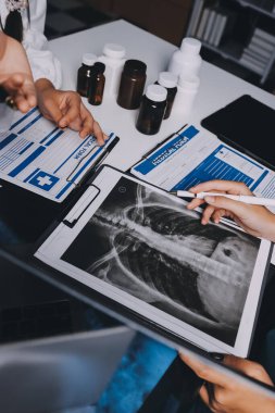 Hastane konferans salonunda kıdemli hekimin sunumu ve sağlık uygulamaları üzerine profesyonel eğitim oturumuna katılan bir grup doktor