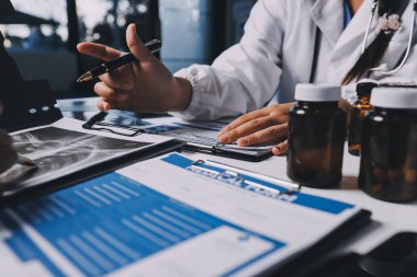 Hastane konferans salonunda kıdemli hekimin sunumu ve sağlık uygulamaları üzerine profesyonel eğitim oturumuna katılan bir grup doktor