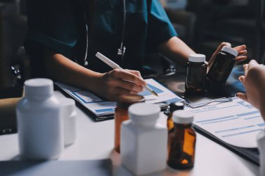 Hastane konferans salonunda kıdemli hekimin sunumu ve sağlık uygulamaları üzerine profesyonel eğitim oturumuna katılan bir grup doktor